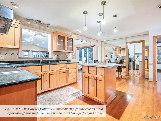 kitchen features custom cabinetry, granite counters, and a passthrough window to the Florida room’s wet bar | Image 10