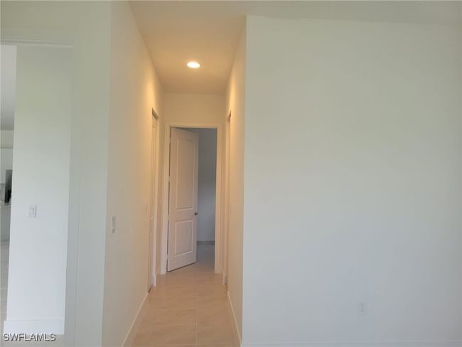 Corridor with light tile patterned floors, recessed lighting, and baseboards | Image 11