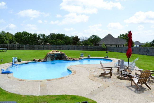 View of pool with a fenced backyard, a patio area, and an outdoor fire pit | Image 34
