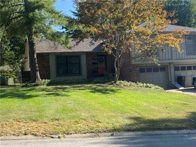 View of front facade with a garage and a front yard | Image 1