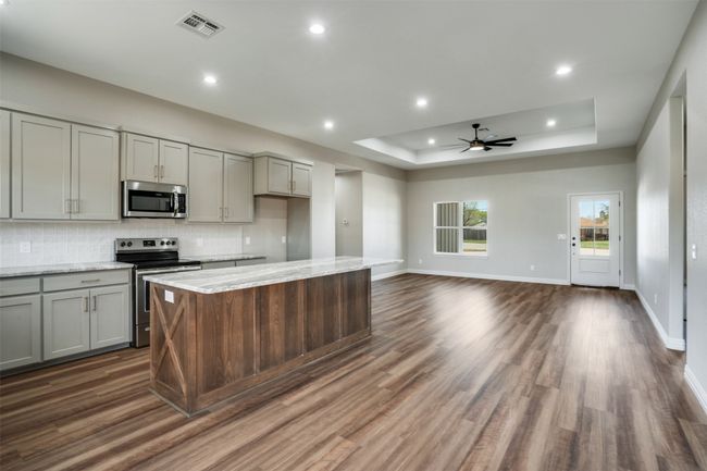 Kitchen featuring stainless steel appliances, a ceiling fan, visible vents, and gray cabinets | Image 8