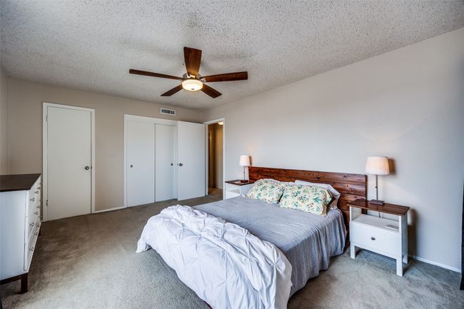 Carpeted bedroom featuring a ceiling fan and a textured ceiling | Image 13