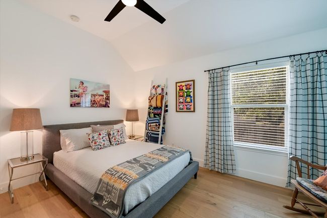Bedroom featuring wood finished floors, lofted ceiling, baseboards, and a ceiling fan | Image 21