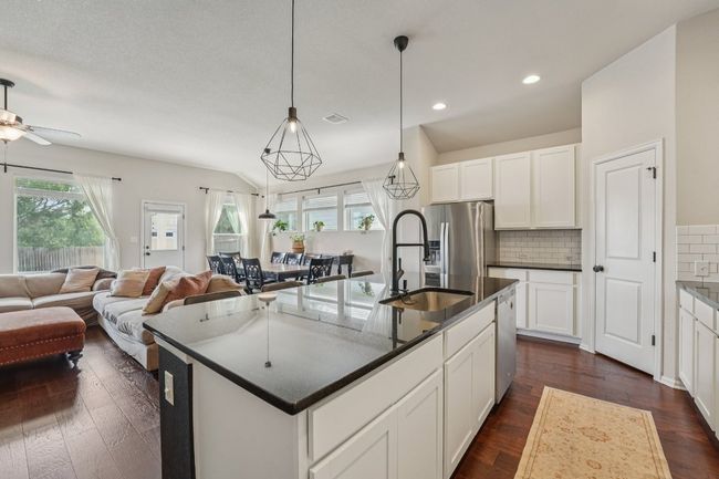 Large kitchen island with granite countertops and crisp white cabinets. Walk-in pantry for great storage | Image 9