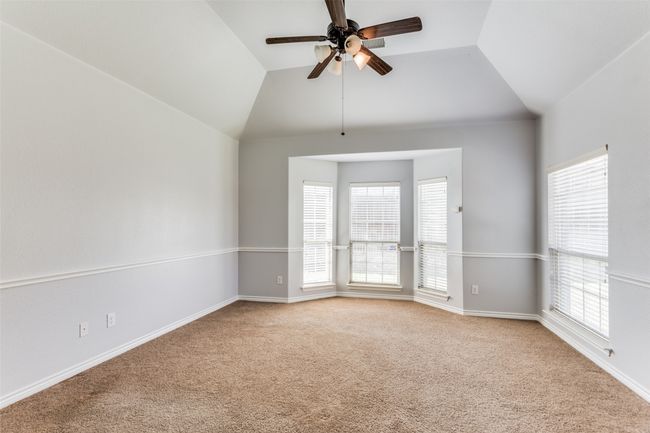 Unfurnished room with light colored carpet, ceiling fan, and lofted ceiling | Image 17