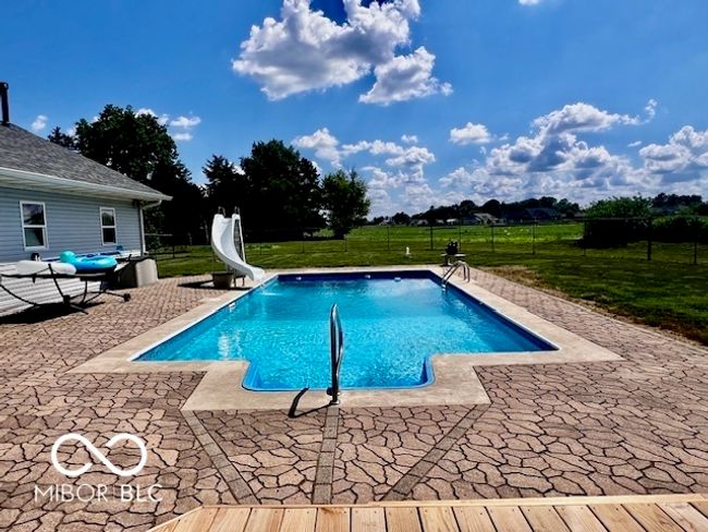 view of swimming pool featuring a water slide and a patio area | Image 69