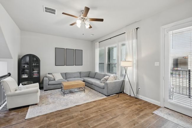 Living area featuring a ceiling fan, baseboards, visible vents, and wood finished floors | Image 14