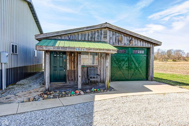 view of front of house featuring concrete driveway, a garage, and metal roof | Image 7