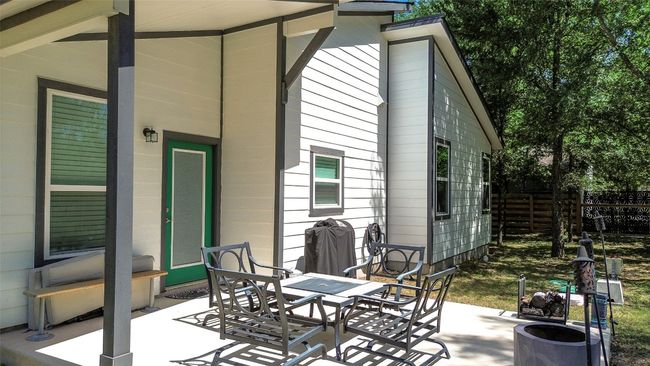Tree-shaded backyard view of the house. | Image 7