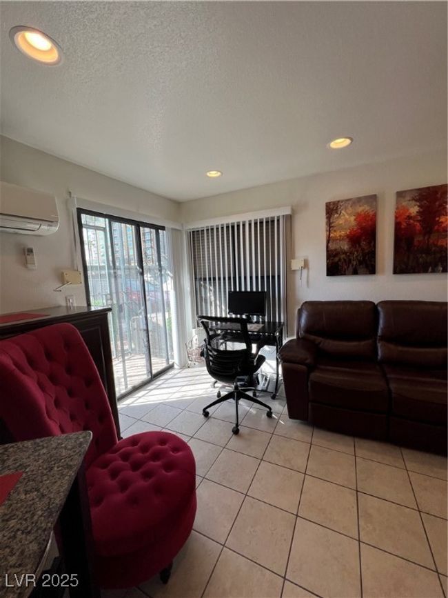 Living area with light tile patterned floors, a wall mounted AC, a textured ceiling, and recessed lighting | Image 29