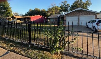 View of gate featuring a garage | Image 1