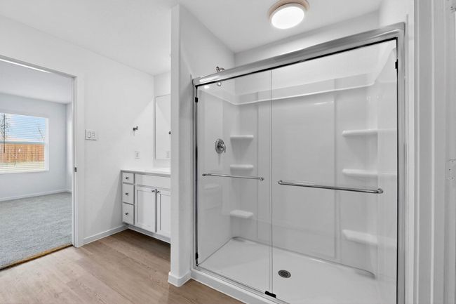 Bathroom featuring a shower stall, vanity, wood finished floors, and baseboards | Image 21