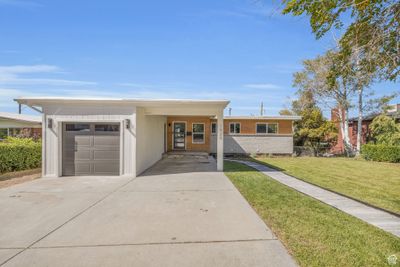 View of front of property featuring a garage, a carport, and a front yard | Image 1