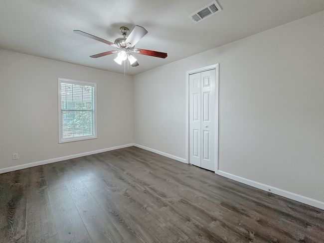 Empty room with dark wood-type flooring and ceiling fan | Image 22