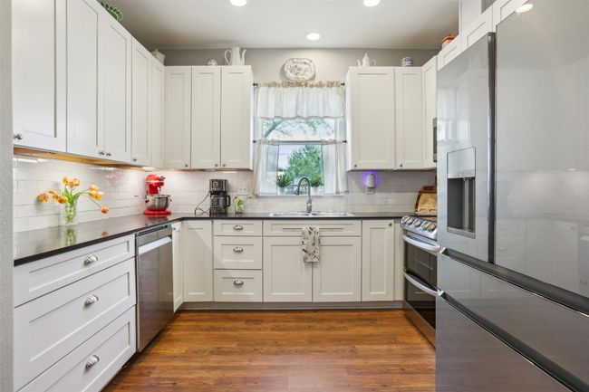 Kitchen with recessed lighting, decorative backsplash, stainless steel appliances, Corian countertops, and a sink | Image 14