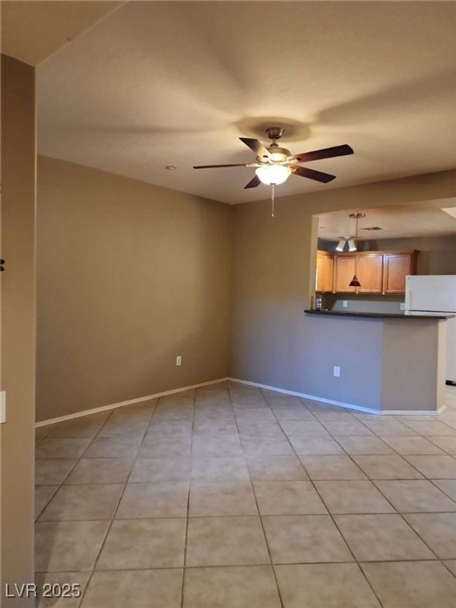 Spare room featuring light tile patterned floors, a ceiling fan, and baseboards | Image 14