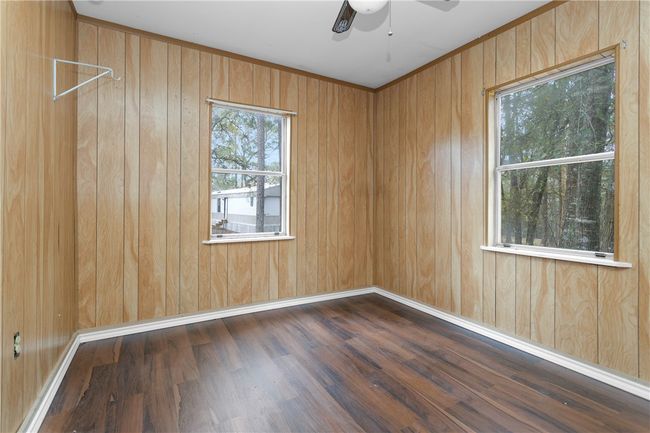 Spare room with a ceiling fan, wood finished floors, and wooden walls | Image 23