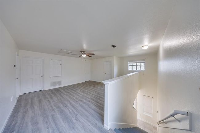 At the top of the stairs, you’re welcomed by an open landing that flows seamlessly into a spacious game room—perfect for movie nights, playtime, or relaxing with family. | Image 19