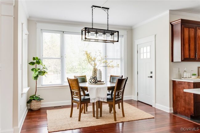 Dining space featuring baseboards, visible vents, ornamental molding, and dark wood-style flooring | Image 16