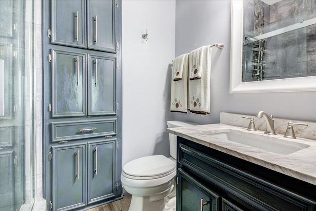 Full bath with vanity, a shower with door, and wood finished floors | Image 13