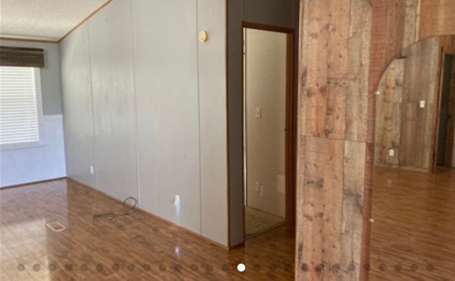 Empty room featuring a decorative wall, a textured ceiling, and wood finished floors | Image 18