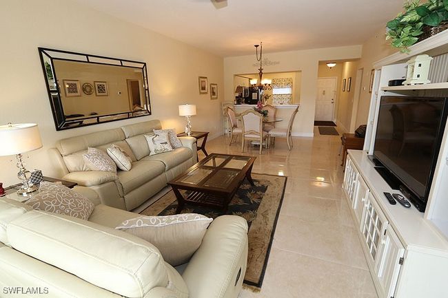 Living room with a notable chandelier and light tile floors | Image 4