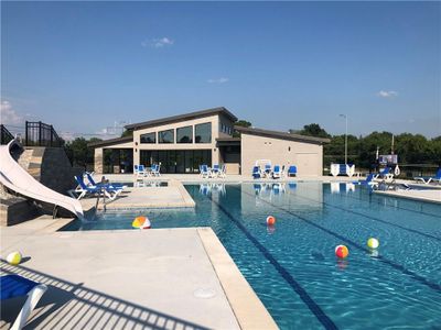 View of swimming pool featuring a water slide and a patio area | Image 3