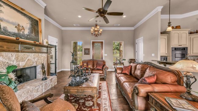 Living area featuring visible vents, dark wood-style floors, ornamental molding, and ceiling fan with notable chandelier | Image 6
