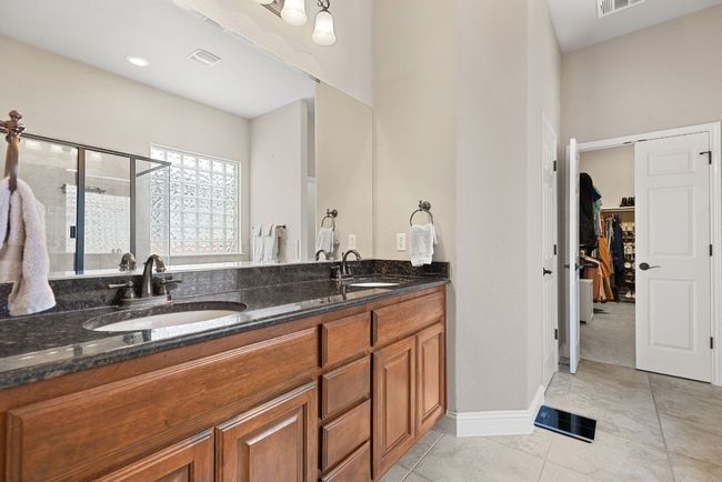 Primary bathroom presents dual vanity sinks with ample counter space. | Image 21