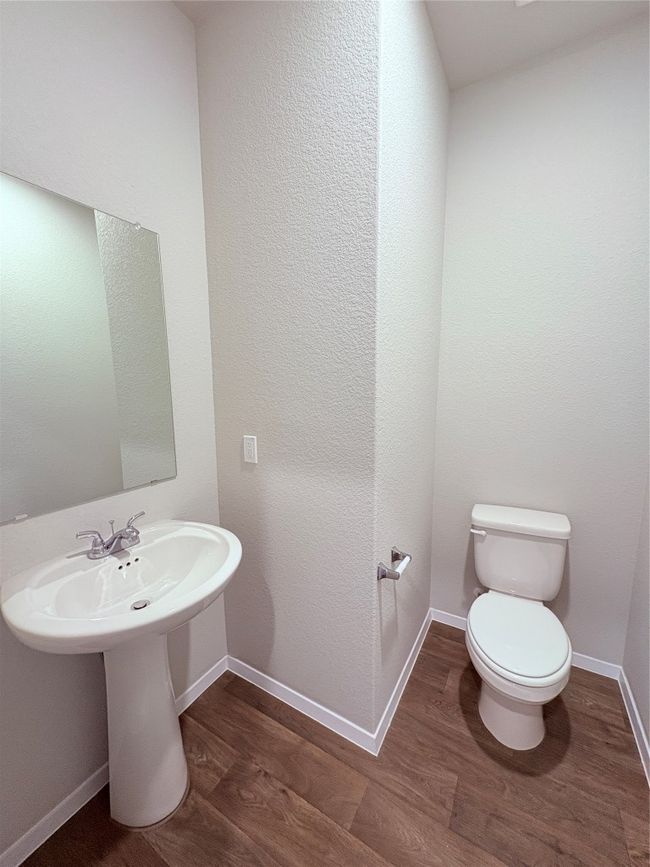 Half bath featuring a sink, toilet, wood finished floors, and baseboards | Image 14