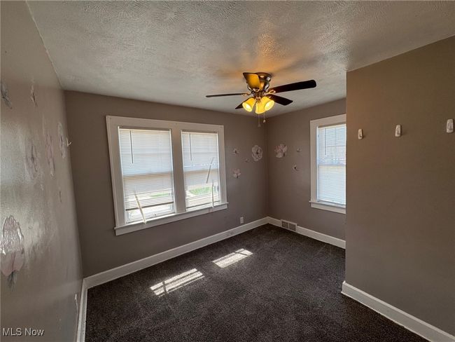 Bedroom featuring a ceiling fan, baseboards, dark carpet, and a textured ceiling | Image 11