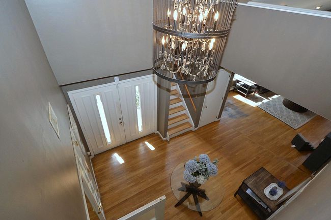 Foyer entrance with an inviting chandelier, a towering ceiling, stairway, and wood finished floors | Image 20