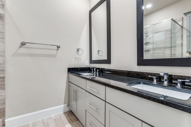 Bathroom with double vanity, a stall shower, and wood finished floors | Image 28