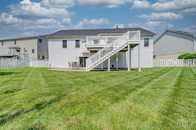 Rear view of property with stairway, a wooden deck, a fenced backyard, and a patio area. | Image 39