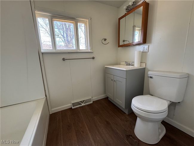 Bathroom featuring visible vents, toilet, vanity, wood finished floors, and baseboards | Image 20