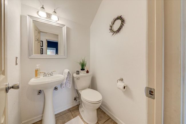 Half bathroom featuring a pedestal sink and tile floors downstairs. | Image 14