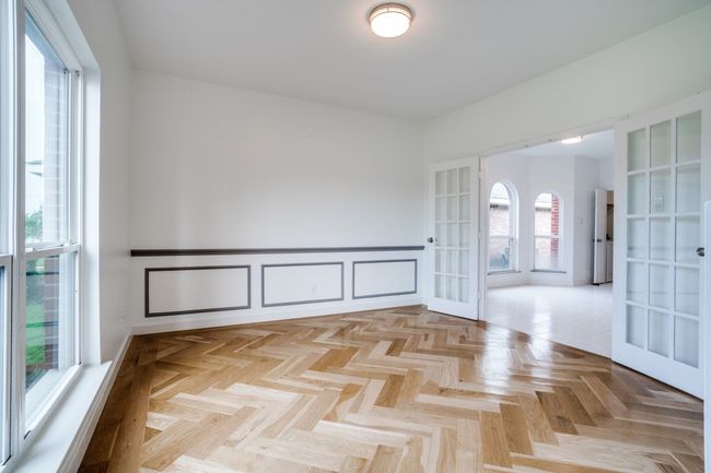 Unfurnished room with a wainscoted wall and french doors | Image 18