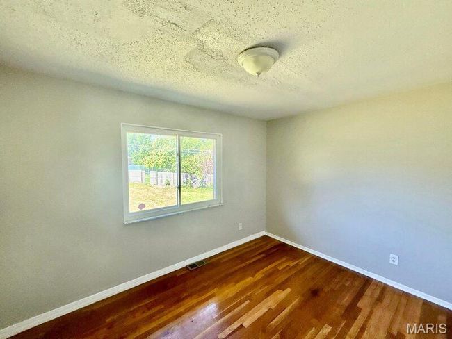 Unfurnished room featuring baseboards, dark wood-style floors, and a textured ceiling | Image 6