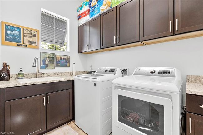 Laundry room featuring washer and clothes dryer, cabinet space, and a sink | Image 50
