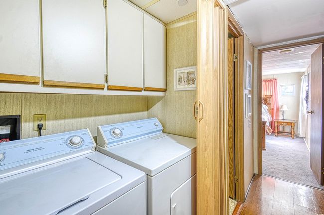 Laundry room featuring light hardwood / wood-style flooring, independent washer and dryer, and cabinets | Image 11