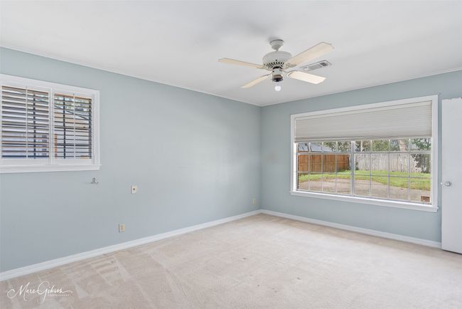 Carpeted empty room featuring visible vents, a ceiling fan, and baseboards | Image 16