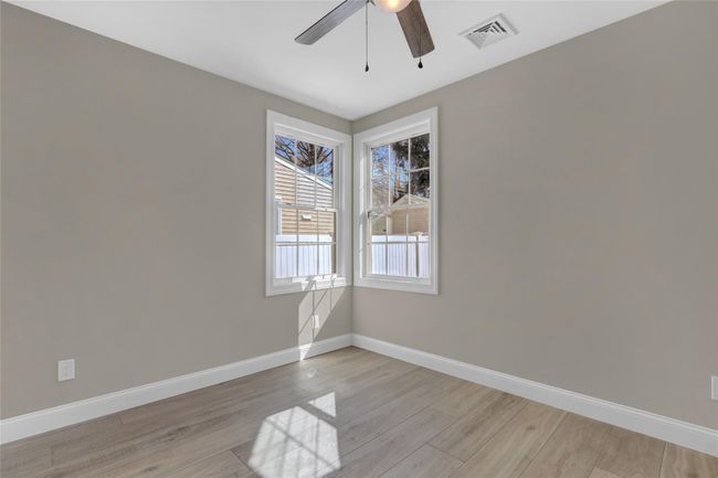 Unfurnished room with a ceiling fan, visible vents, light wood-style flooring, and baseboards | Image 14