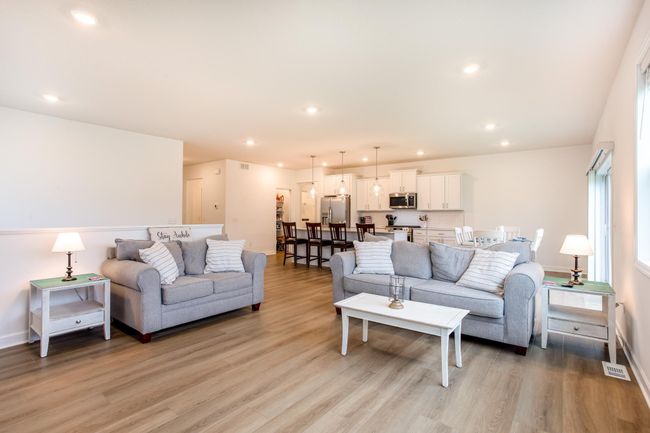 Comfortable and inviting, this spacious living room flows seamlessly into the kitchen and dining areas for ideal main-level living. | Image 14
