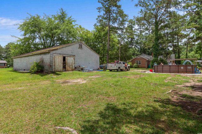 View of green lawn with a pool and an outbuilding | Image 9
