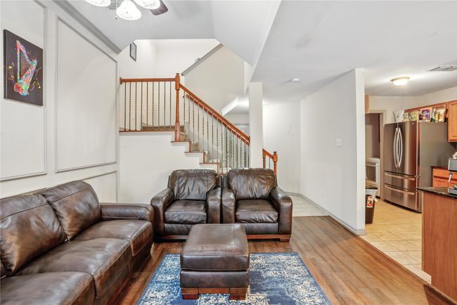 Living area featuring ceiling fan, light wood-style floors, and stairs | Image 8