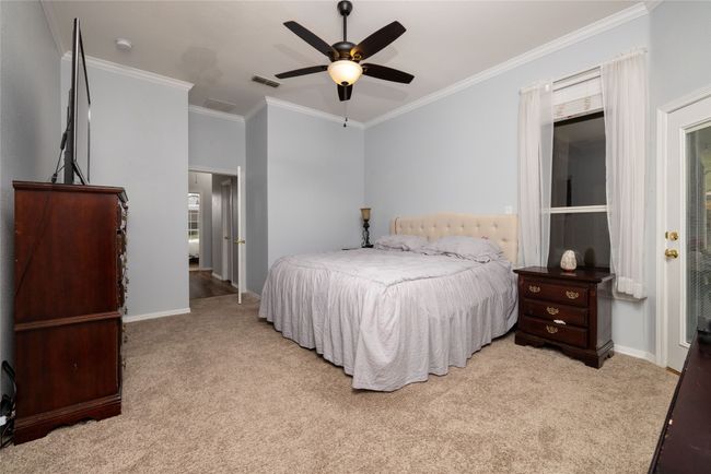 Bedroom featuring light carpet, ornamental molding, visible vents, and baseboards | Image 29
