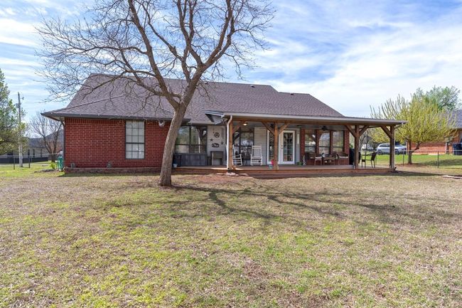 Rear view of house with a yard, brick siding, roof with shingles, and fence | Image 34