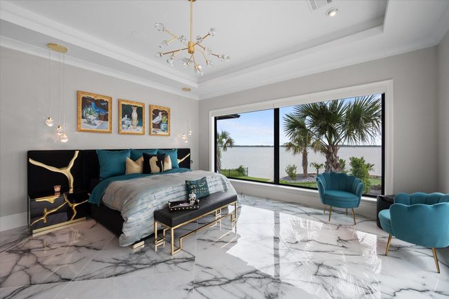 Bedroom with marble finish floor, a raised ceiling, and a notable chandelier | Image 14