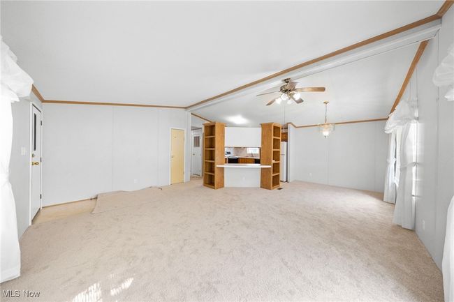 Unfurnished living room featuring ceiling fan, lofted ceiling, and carpet floors | Image 5