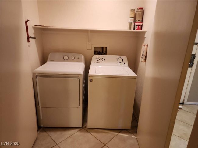 Laundry room featuring light tile patterned floors, laundry area, and washing machine and dryer | Image 22